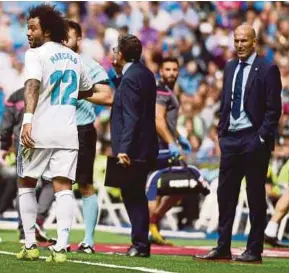  ?? AFP PIC ?? Real Madrid coach Zinedine Zidane (right) looks at his player Marcelo leaving the field after receiving a red card during their La Liga match against Levante at the Santiago Bernabeu on Saturday.