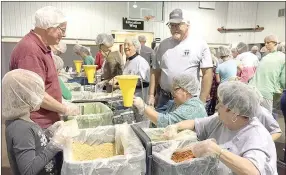  ?? PHOTOS COURTESY PRAIRIE GROVE CHRISTIAN CHURCH ?? Members of Prairie Grove Christian Church put together meals that will be delivered to people in Haiti. The church partnered with The Pack Shack of Rogers for the food. The project was part of the church’s Great Serve, a day set aside to serve the...