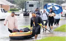  ?? Picture / AP ?? Residents in Baton Rouge take what they can with them as flooding forces them from their homes.