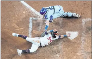  ?? John Bazemore The Associated Press ?? Eddie Rosario scores past Dodgers catcher Will Smith in the eighth inning of the Braves’ 5-4 victory. Rosario went 4-for-5 with a walk-off RBI single.