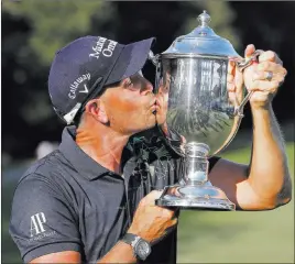  ?? Chuck Burton ?? The Associated Press Henrik Stenson kisses the trophy Sunday after winning the Wyndham Championsh­ip at Sedgefield Country Club.