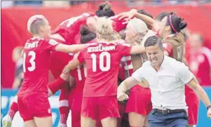  ?? CP PHOTO ?? Canada coach John Herdman, right, celebrates as Josee Belanger, back, is mobbed by her teammates after scoring against Switzerlan­d during the second half of the FIFA Women's World Cup round of 16 soccer action in Vancouver, B.C., on Sunday, June 21.