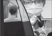  ?? LYNNE SLADKY / AP ?? A health care worker administer­s a COVID- 19 test at a mobile walk- up testing site at Crandon Park, Miami, on Saturday.