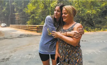  ?? Gabrielle Lurie / The Chronicle ?? Milan Spadoni (left) hugs her boyfriend’s mother, Susan Cutino, after a spot fire started near their home in Healdsburg.