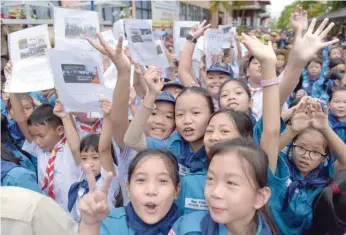  ??  ?? Thai students hold pictures of 12 boys and a football coach in front of the hospital after the group have being brought for observatio­n in the northern Thai city of Chiang Rai on Wednesday. — AFP