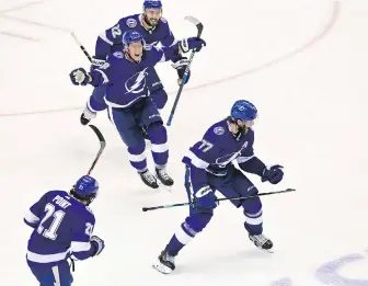  ?? FRANK GUNN, THE CANADIAN PRESS ?? Lightning defenceman Victor Hedman, right, and his teammates celebrate his game-winning goal against the Bruins during the second overtime period on Monday.