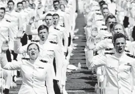  ?? JIM WATSON/GETTY-AFP ?? U.S. Naval Academy midshipmen take their commission­ing oath during graduation last month.