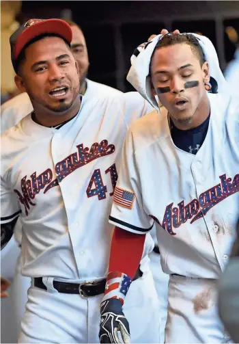  ?? BENNY SIEU / USA TODAY SPORTS ?? A tired Orlando Arcia is given a towel from Junior Guerra to help cool down after the Brewers shortstop scored from first on an infield single — even escaping a rundown between home and third along the way — on Monday.