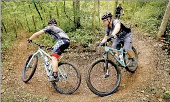  ?? Ben Goff/NWA Democrat-Gazette ?? Max Smith, left, of Bella Vista, leads Steve Friedman of St. Louis, Mo., and Matt Johnson of Festus, Mo., on a ride on Sunday on a section of the Back 40 Loop mountain bike trail system near Lake Ann in Bella Vista.