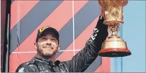  ?? LARS BARON / EFE ?? Localía. Hamilton levanta el trofeo de ganador, pese a ser sancionado por un golpe.