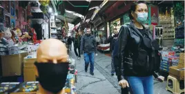  ?? (Umit Bektas/Reuters) ?? A WOMAN WEARING a protective face mask walks in a market at Eminonu neighborho­od of Istanbul, Turkey, yesterday.