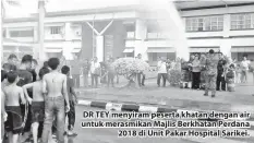  ??  ?? DR TEY menyiram peserta khatan dengan air untuk merasmikan Majlis Berkhatan Perdana 2018 di Unit Pakar Hospital Sarikei.