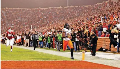  ?? [PHOTO BY SARAH PHIPPS, THE OKLAHOMAN ARCHIVES] ?? Oklahoma State’s Tyreek Hill runs a punt back to tie the game during Bedlam in 2014 at Gaylord Family—Oklahoma Memorial Stadium in Norman.