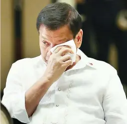  ??  ?? MOVED BY A SONG – President Duterte wipes a tear as he gets emotional while listening to members of the Our Lady of Victory Training Center sing 'You Raise Me Up,' one of his favorites. The President hosted a dinner at Malacañang for the center members...