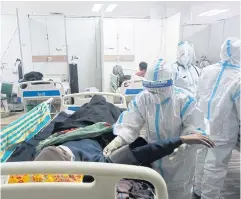  ?? BLOOMBERG ?? A healthcare worker wearing protective equipment checks the vitals of a patient inside a Covid-19 treatment facility in New Delhi, India on Jan 5, 2022.