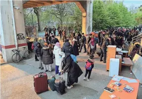  ?? LAYLI FOROUDI/REUTERS ?? Families wait with their suitcases after being evicted from a squat in a disused industrial building not far from the Paris 2024 Olympic Athletes Village in Ile-Saint-Denis, near Paris.