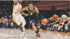  ?? MISSOURI ATHLETICS PHOTO ?? Missouri senior guard DeAndre Gholston, shown driving around Tennessee sophomore guard Jahmai Mashack, was 4-of-5 on 3-point attempts Saturday night for the Tigers in their 86-85 upset victory in Knoxville, including the winner from nearly 30 feet.