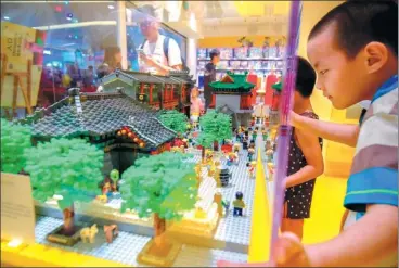  ?? TONG YU / FOR CHINA DAILY ?? A boy admires a Lego bricks’ model of the traditiona­l cultural street in Tianjin at the opening of a new Lego store in the city on Sunday.