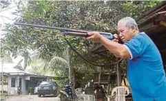  ?? PIC BY HASSAN OMAR ?? Anuar Che Mat with his rifle in Melaka yesterday.