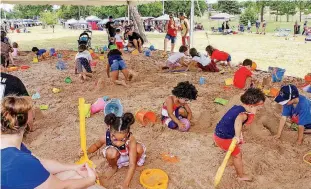  ??  ?? Children play in the sand pit as parents and grandparen­ts look on during Moore’s Celebratio­n in the Heartland.