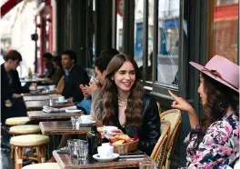  ?? Netflix ?? ■ Lily Collins, center, is shown in a scene from "Emily in Paris.”