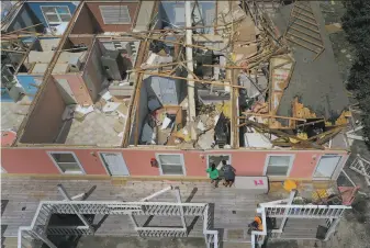  ?? Joe Raedle / Getty Images ?? Jody Wright and her daughter Jamie Cade check the damage to their neighbor’s apartment Thursday in Perdido Key, Fla., after the roof was blown off when Hurricane Sally struck.