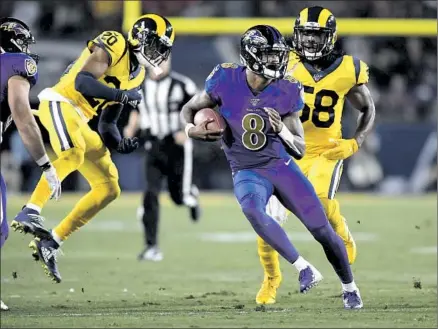  ?? Photograph­s by Wally Skalij Los Angeles Times ?? LAMAR JACKSON ran wild against Jalen Ramsey (20), Cory Littleton and the Rams, rushing for 95 yards, while picking them apart through the air, throwing five touchdown passes. At 6-5, the defending NFC champions are on the brink of missing the playoffs.