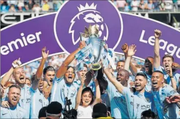  ?? REUTERS PHOTO ?? Manchester City were handed the Premier League trophy at the Etihad Stadium on Sunday.