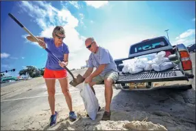  ?? (AP/The Sun Herald/Alyssa Newton) ?? Kim Miller and Monty Graham fill sandbags Sunday along U.S. 90 in Gulfport, Miss., as residents get ready for Tropical Storm Sally.