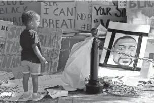  ?? RICH PEDRONCELL­I/ASSOCIATED PRESS ?? Kyrie Harris, 2, looks at a drawing of George Floyd at a Juneteenth rally Friday in Sacramento, Calif. Juneteenth marks the day in 1865 when federal troops arrived in Galveston, Texas, to take control of the state and ensure all enslaved people be freed, more than two years after the Emancipati­on Proclamati­on.