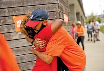  ?? STAFF PHOTOS BY DOUG STRICKLAND ?? Logan Taylor, right, hugs Satedra Smith, whose son Jordan Clark was killed in a shooting in 2015. The two were attending a Gun Violence Awareness Day event Saturday. The group walked from the Blue Goose Hollow trailhead along the Tennessee Riverwalk to...