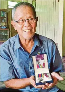  ?? PIC BY MOHAMED SAHIDI YUSOFF ?? Mohamed Asari Che Derahman showing the medals he received for his service at his home in Kampung Lubok Bongor Baru in Jeli.