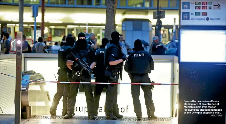  ??  ?? Special forces police officers stand guard at an entrance of Munich’s main train station following the shooting rampage at the Olympia shopping mall.