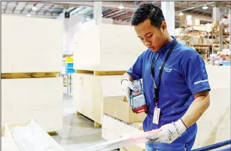  ??  ?? This photograph taken on March 4, 2018 shows a staff member scanning an aircraft part at the Satair regional storage facility in Singapore’s Seletar Aerospace Park. Airbus and Boeing may have built their global success on the back of the...