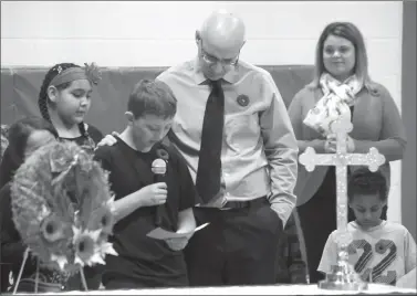  ?? Herald photo by J.W. Schnarr @JWSchnarrH­erald ?? Grade 5 student Noah Meldrum has some help from associate principal Lyle Parr during the The Children of St. Martha Elementary School Remembranc­e Day ceremony on Wednesday.