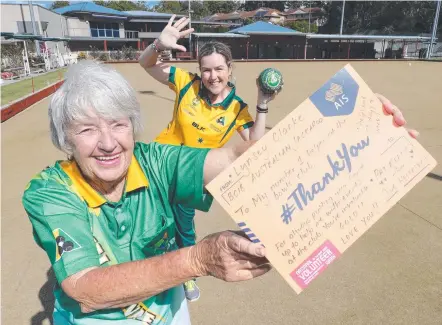  ?? Picture: GLENN HAMPSON ?? Volunteer Pat Reely with a thankyou post from bowls great Lynsey Clarke (rear) at Club Helensvale.