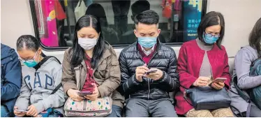  ??  ?? Mit Mundschutz in der U-Bahn. In Hongkong verhängte die Regierung einen „Virus-Notstand“.