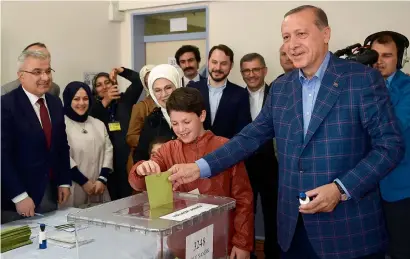  ?? AFP ?? President Recep Tayyip Erdogan casts his vote accompanie­d by his wife Emine Erdogan (3rd right) and their grandchild­ren at a polling station in the Uskudar district of Istanbul on Sunday. —