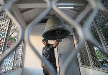  ?? ?? during the fasting month, Muizzuddin is one of the individual­s tasked with the daily responsibi­lity of ringing the bell. — Photos: Bernama