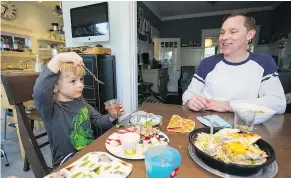  ??  ?? Nolan Tupper is poised to dig into his desert as his father Bryce looks on in bemusement. The Tupper family uses one of about a dozen Vancouver startups that prepare meals and deliver them.