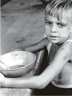  ?? Foto: Sammlung Michael Andreas Wahle ?? Aus einer Blechschüs­sel löffelt dieser Flüchtling­sbub eine dünne Suppe. Dieses Foto ist eines der Exponate auf der Sonderauss­tellung „Kindheit in der Nachkriegs­zeit 1945   1955“.