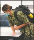  ?? (AP/Julio Cortez) ?? A midshipman uses a sanitizing wipe to clean her desk before the start of a leadership class at the Naval Academy in Annapolis, Md.