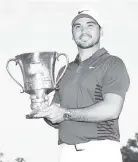  ?? — AFP photo ?? Jason Day of Australia poses with the trophy on the 18th green after winning the 2018 Wells Fargo Championsh­ip at Quail Hollow Club.