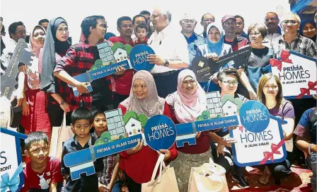  ??  ?? Home ownership: Najib (centre) having a chat after presenting a mock key to one of the PR1MA home owners during the launch of the expo at the Putra World Trade Centre in Kuala Lumpur.