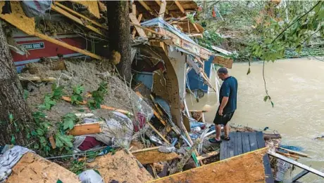  ?? AUSTIN ANTHONY/THE NEW YORK TIMES ?? Kenneth Neace examines the remains of his home Friday after it was destroyed by flooding in Breathitt County, Kentucky. Water has poured down hillsides into valleys in the region, swamping whole towns.