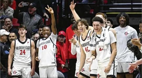  ?? DENIS POROY/ASSOCIATED PRESS ?? San Diego State players celebrate an 81-67 victory over Utah State on Feb. 3 at raucous Viejas Arena. The Aztecs, one-time weaklings of the Mountain West, knocked off No. 1 overall seed Alabama in last year’s NCAA Tournament and made it all the way to the championsh­ip game before losing to Connecticu­t.