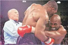 ?? FOTO: JEFF HAYNES/DPA ?? Moment der Sportgesch­ichte: Mike Tyson (Mi.) beißt dem damaligen Weltmeiste­r Evander Holyfield (re.) ein Stück des rechten Ohrs ab.