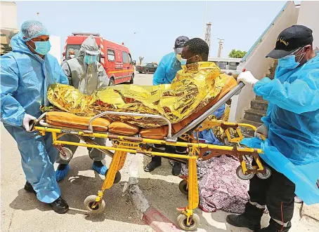  ?? File/AFP ?? Medics transport a migrant at the port of El-Ketef in southern Tunisia near the border with Libya. The migrant was rescued by Tunisia’s national guard.