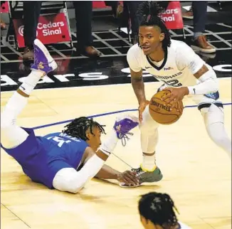  ?? Marcio Jose Sanchez Associated Press ?? NOT MANY have found a way to stop Memphis guard Ja Morant in his young career, so Clippers guard Terance Mann tries something new by grabbing the Grizzlies’ star by the shoe.