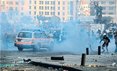  ?? JOSEPH EID AFP VIA GETTY IMAGES ?? Lebanese protesters clash with security forces in Beirut on Saturday following a demonstrat­ion against political leadership.